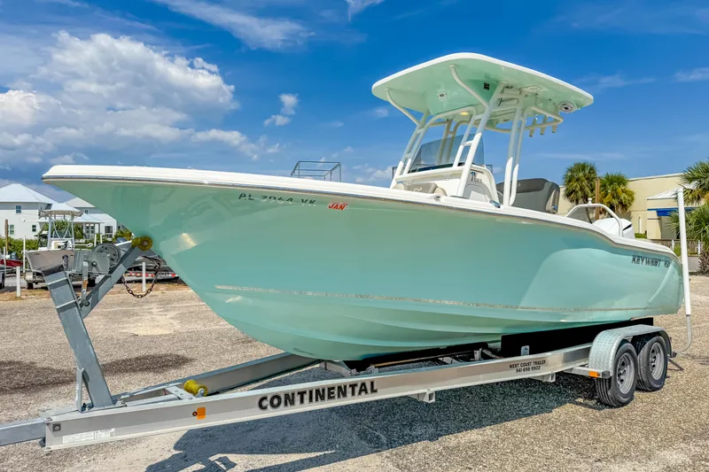 Slide: The Image of 2021 Key West 239 FS boat on trailer under clear blue sky. - 2