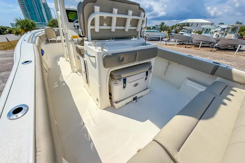 Slide: The Image of 2021 Key West 239 FS boat interior with seating and storage, docked outdoors. - 23