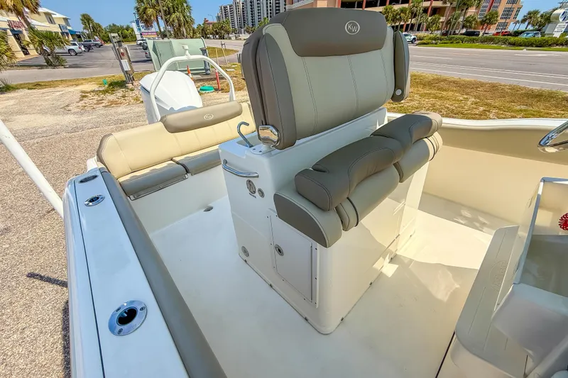 Slide: The Image of 2021 Key West 239 FS boat interior with cushioned seating and console, parked outdoors. - 25