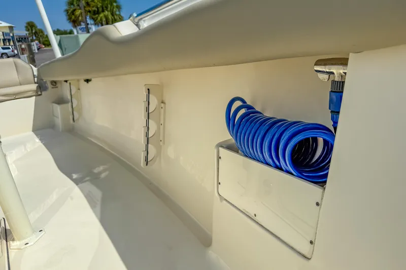 Slide: The Image of 2021 Key West 239 FS boat interior with blue coiled hose and storage compartment. - 30