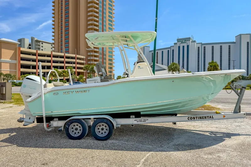 Slide: The Image of 2021 Key West 239 FS boat on trailer, parked near tall buildings. - 4