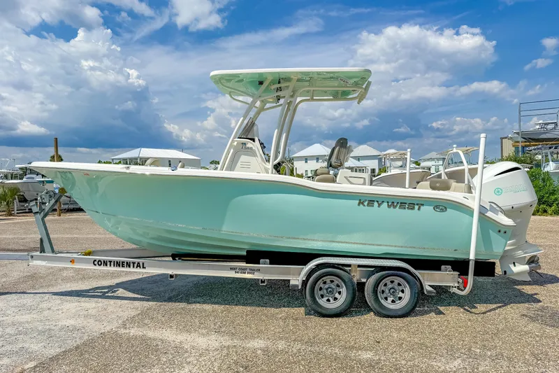 Slide: The Image of 2021 Key West 239 FS boat on trailer under a partly cloudy sky. - 6