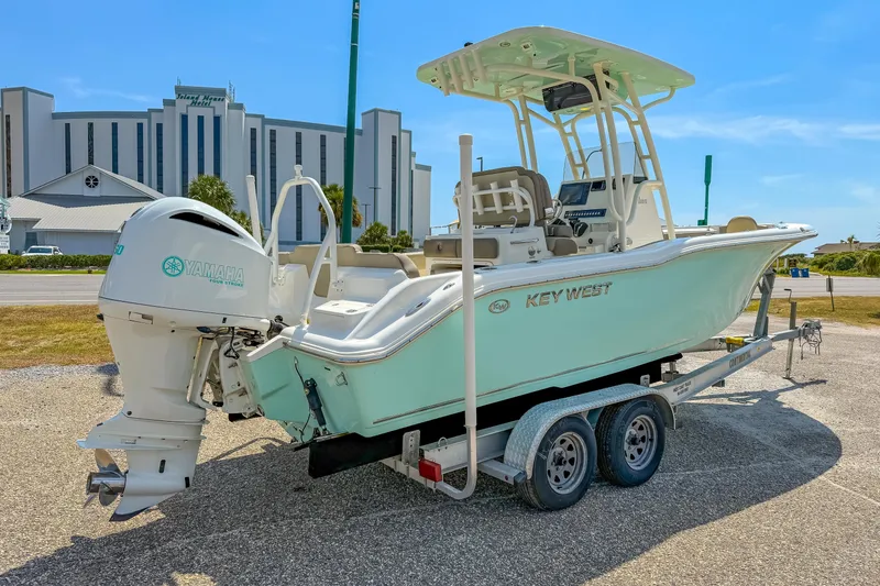Slide: The Image of 2021 Key West 239 FS boat on trailer with Yamaha engine, parked near a hotel. - 7