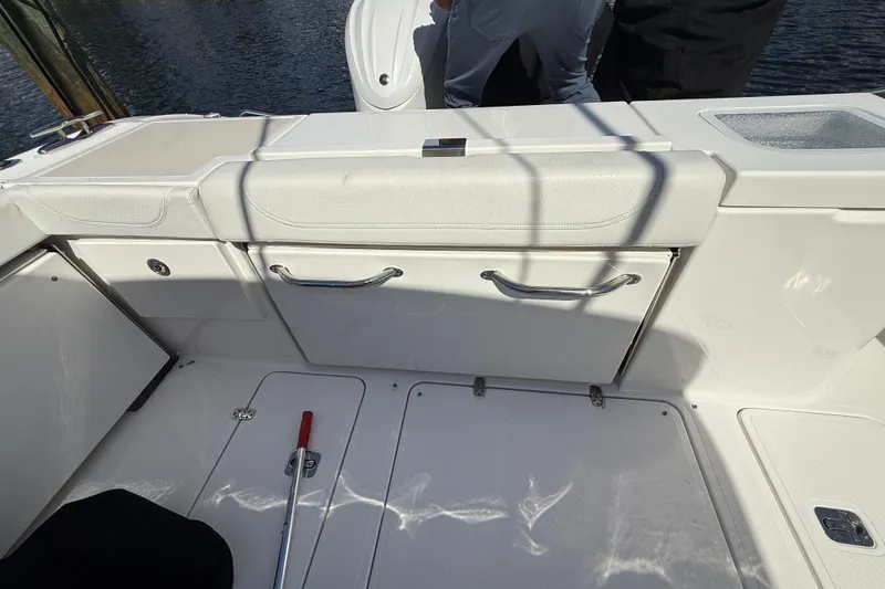 Slide: The Image of 2023 Pursuit OS 355 Offshore boat interior with white seating and storage compartments. - 20