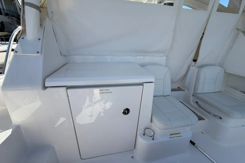 Slide: The Image of 2023 Pursuit OS 355 Offshore boat interior with white seating and storage compartment. - 23