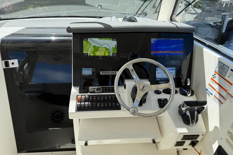 Slide: The Image of 2023 Pursuit OS 355 Offshore helm with navigation screens and controls. - 25