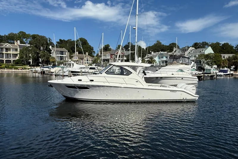 Slide: The Image of 2023 Pursuit OS 355 Offshore boat docked in a scenic marina. - 3