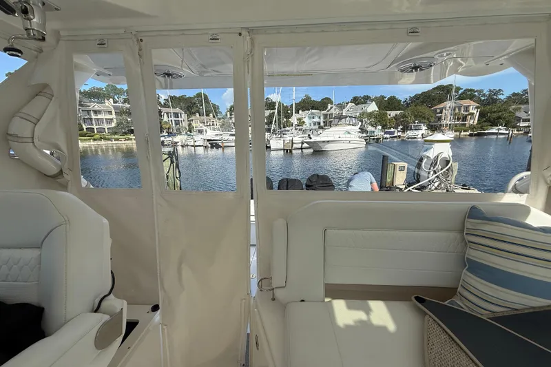 Slide: The Image of 2023 Pursuit OS 355 Offshore interior view, overlooking marina with boats and waterfront homes. - 32