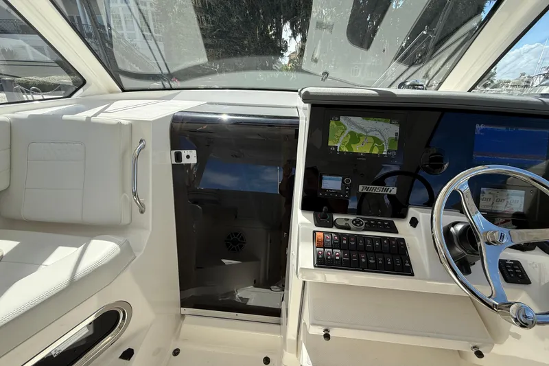 Slide: The Image of 2023 Pursuit OS 355 Offshore boat cockpit with navigation system and steering wheel. - 33