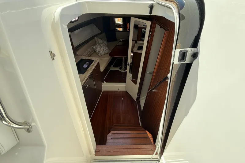 Slide: The Image of Interior view of 2023 Pursuit OS 355 Offshore boat, featuring elegant wood finishes. - 35