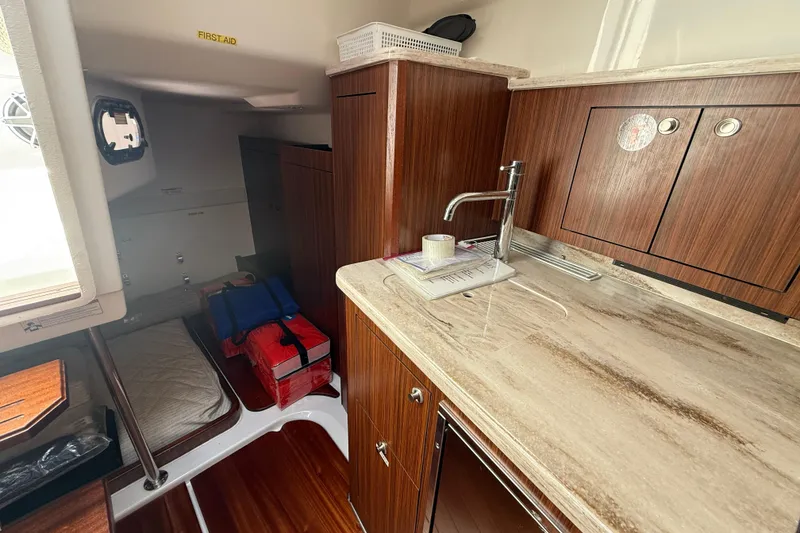 Slide: The Image of 2023 Pursuit OS 355 Offshore cabin interior with kitchenette and sleeping area. - 37