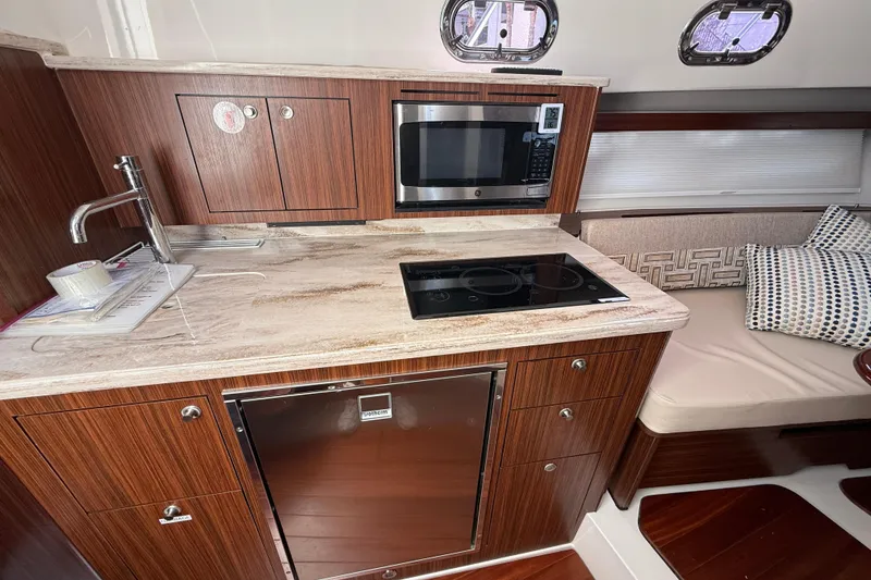Slide: The Image of 2023 Pursuit OS 355 Offshore yacht kitchen with modern appliances and elegant wood finish. - 38