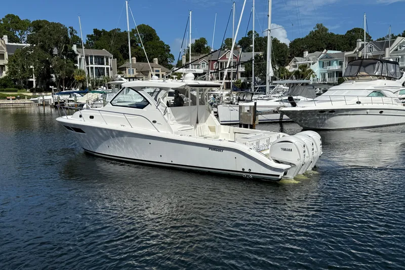 Slide: The Image of 2023 Pursuit OS 355 Offshore boat docked in a marina with other yachts. - 4