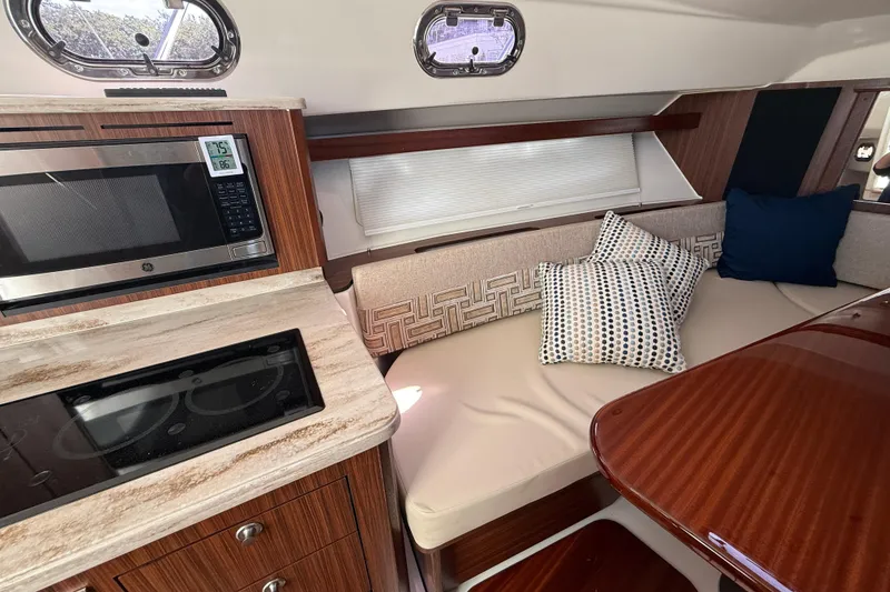 Slide: The Image of 2023 Pursuit OS 355 Offshore interior with kitchen and cozy seating area. - 42