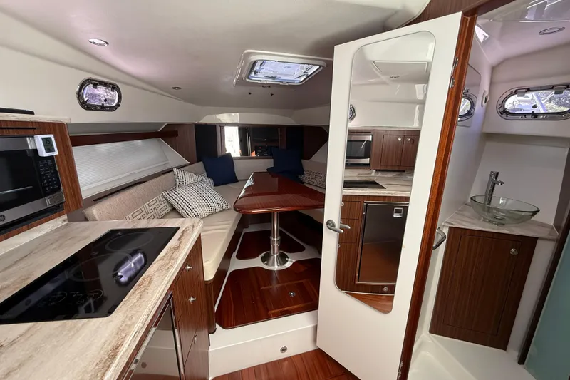 Slide: The Image of 2023 Pursuit OS 355 Offshore cabin interior with modern kitchen and seating area. - 43
