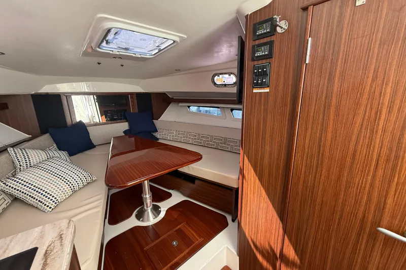 Slide: The Image of 2023 Pursuit OS 355 Offshore cabin interior with wood finish and seating area. - 45