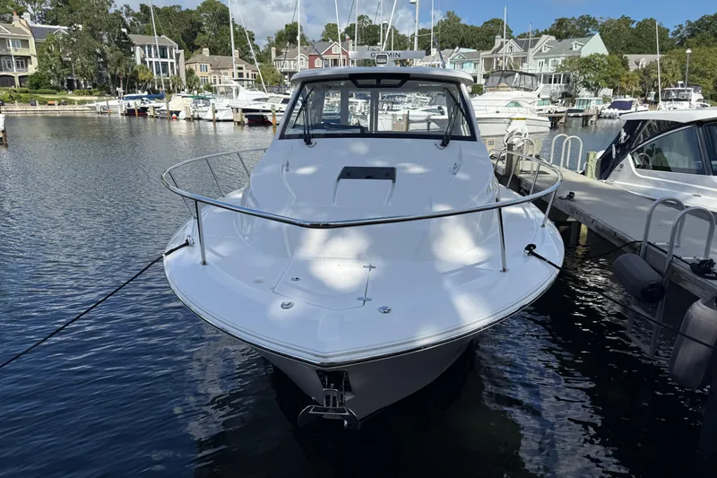 Slide: The Image of 2023 Pursuit OS 355 Offshore boat docked in a marina, surrounded by other vessels. - 49
