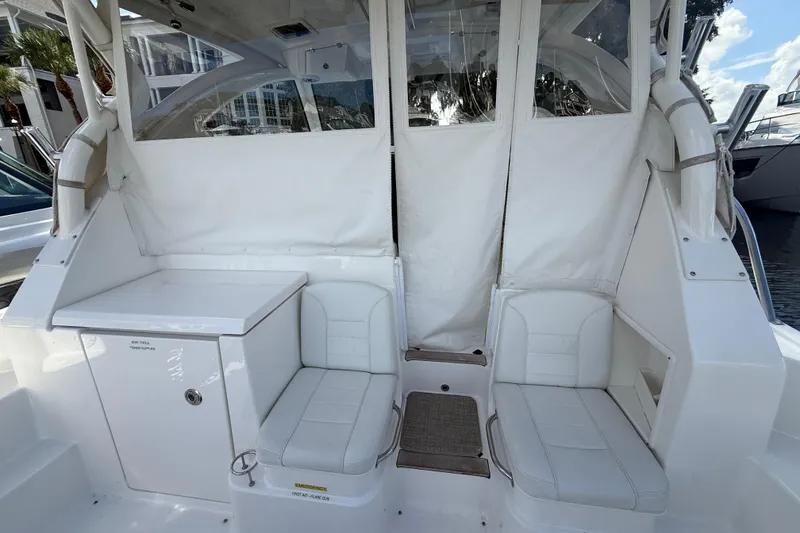 Slide: The Image of 2023 Pursuit OS 355 Offshore boat interior with white seating and storage compartments. - 50