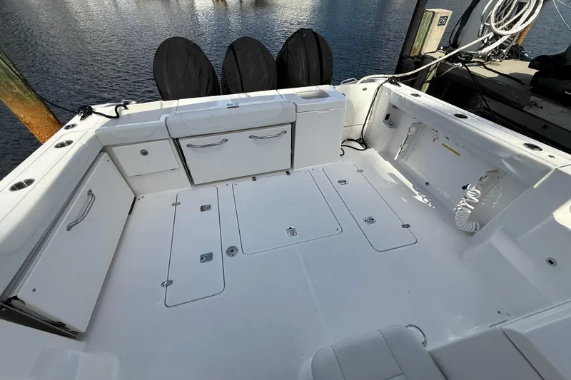 Slide: The Image of 2023 Pursuit OS 355 Offshore boat deck with storage compartments and clean white finish. - 52