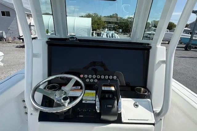 Slide: The Image of 2025 Wellcraft 243 Fisherman boat dashboard with steering wheel and controls. - 5