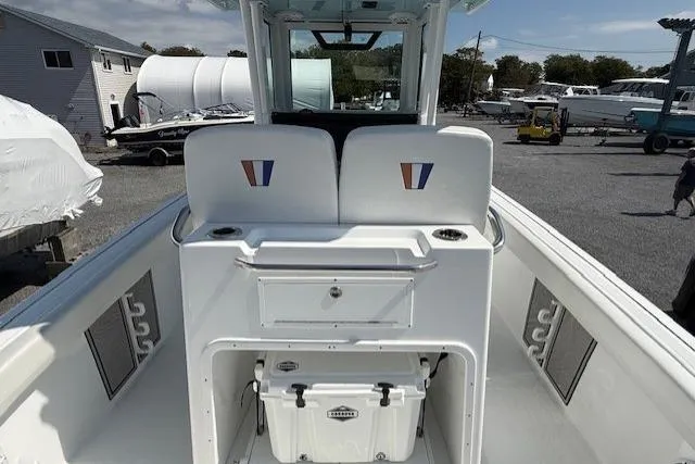 Slide: The Image of 2025 Wellcraft 243 Fisherman boat interior with seating, storage, and cooler on deck. - 9