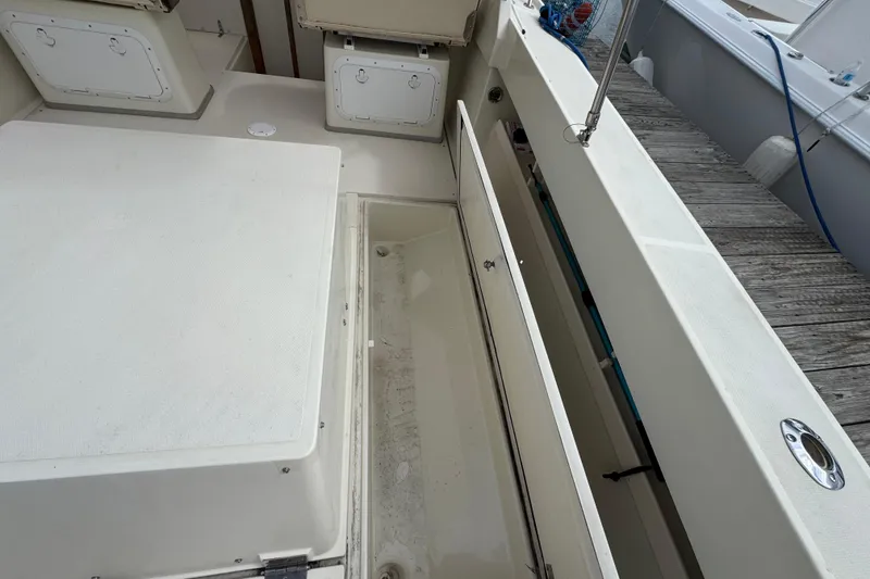 Slide: The Image of 2006 Limestone 26 boat interior with storage compartments and seating area. - 13