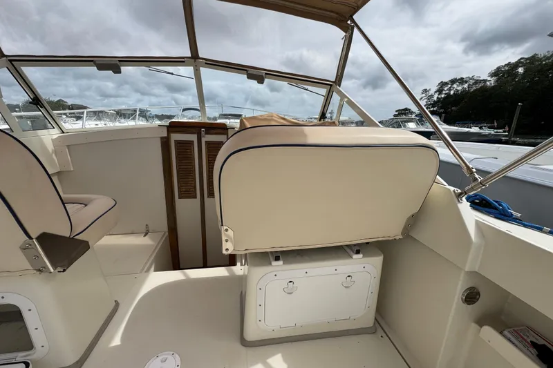 Slide: The Image of 2006 Limestone 26 boat interior with beige seating and storage compartments. - 15