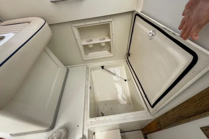 Slide: The Image of 2006 Limestone 26 boat interior storage compartment with open hatch and seating area. - 19