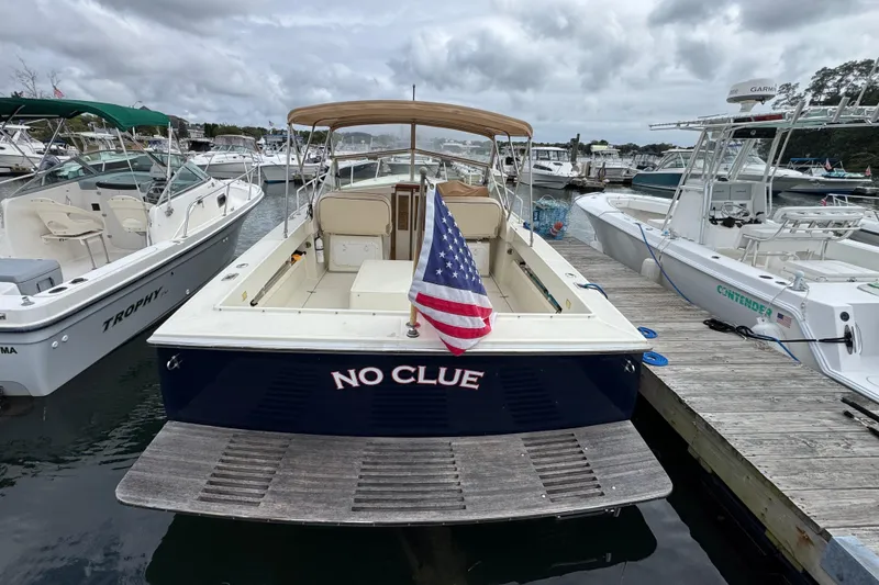 Slide: The Image of 2006 Limestone 26 boat named "No Clue" docked with American flag displayed. - 3