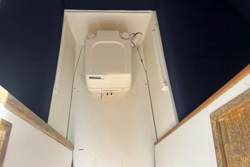Slide: The Image of Compact marine toilet in a 2006 Limestone 26 boat cabin. - 30