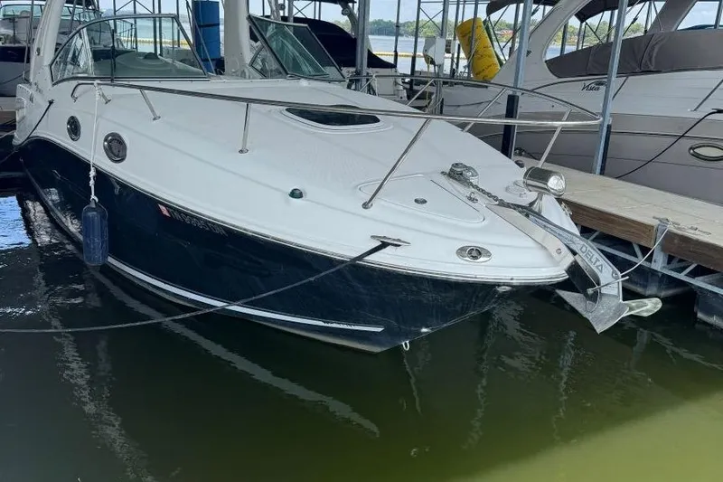 Slide: The Image of 2006 Sea Ray 260 Sundancer docked in a marina, featuring sleek design and modern amenities. - 2