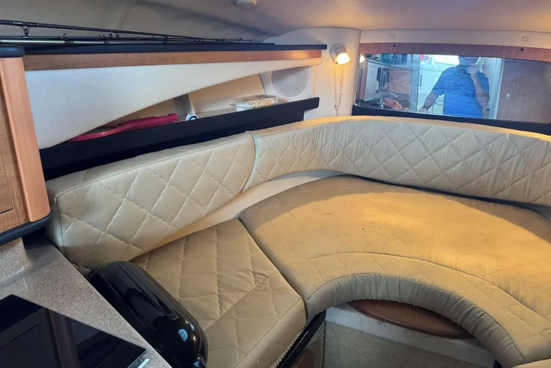 Slide: The Image of Interior of 2006 Sea Ray 260 Sundancer with beige quilted seating and wooden accents. - 25