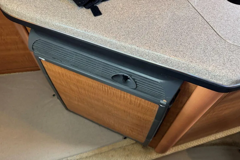 Slide: The Image of 2006 Sea Ray 260 Sundancer interior with compact wooden cabinet and countertop. - 30