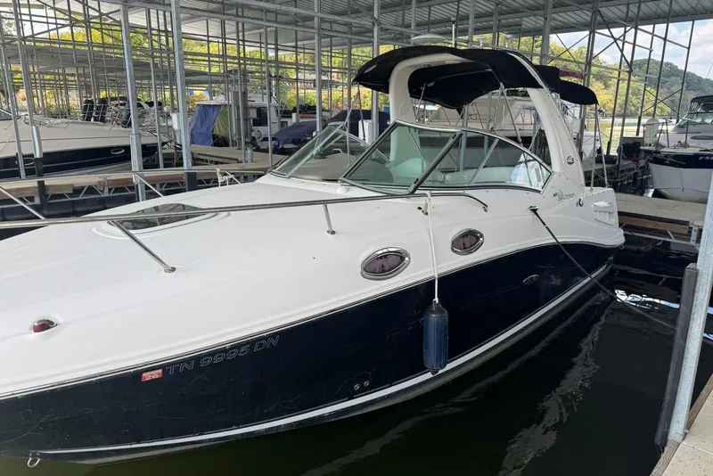 Slide: The Image of 2006 Sea Ray 260 Sundancer docked in a marina, featuring sleek design and black hull. - 6