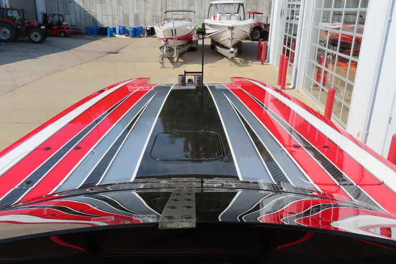 Slide: The Image of 2021 Wright Performance 360 Carbon boat with sleek red, black, and white design in a marina setting. - 12