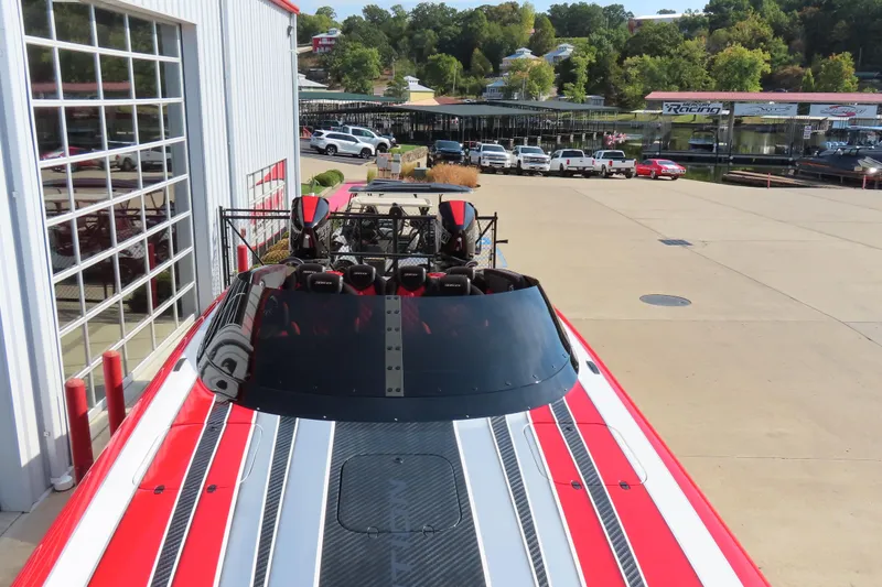 Slide: The Image of 2021 Wright Performance 360 Carbon boat with red and white stripes, parked near a marina. - 24