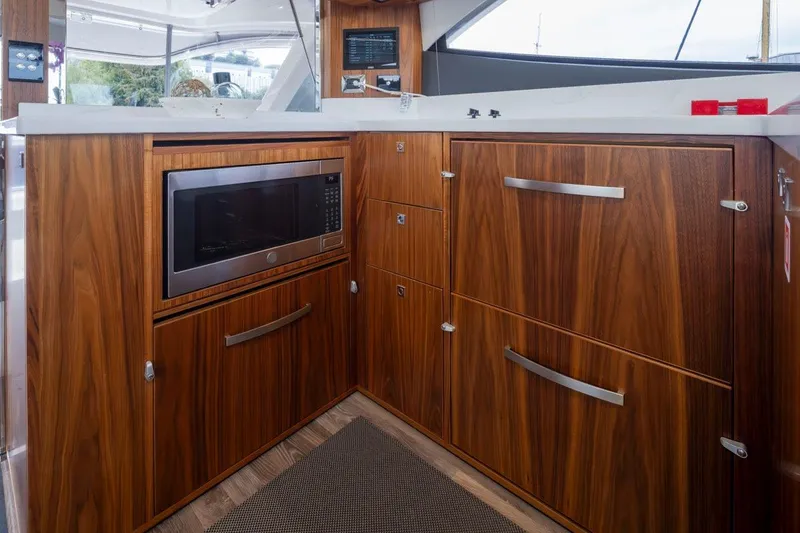 Slide: The Image of Luxurious wood-finished kitchen in 2023 Riviera 505 SUV yacht with modern appliances. - 10