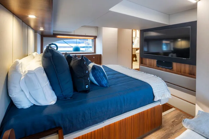 Slide: The Image of Luxurious interior of 2023 Riviera 505 SUV yacht with cozy bed and modern TV. - 14