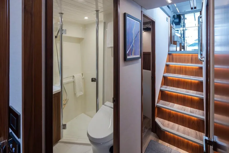 Slide: The Image of Interior of 2023 Riviera 505 SUV yacht featuring modern bathroom and illuminated staircase. - 16