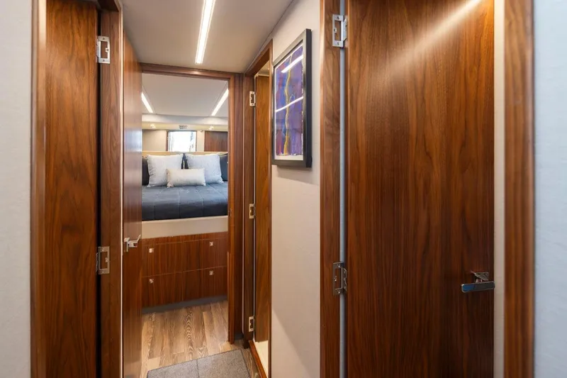 Slide: The Image of Luxurious interior hallway of 2023 Riviera 505 SUV yacht with wooden doors and cozy bedroom. - 23