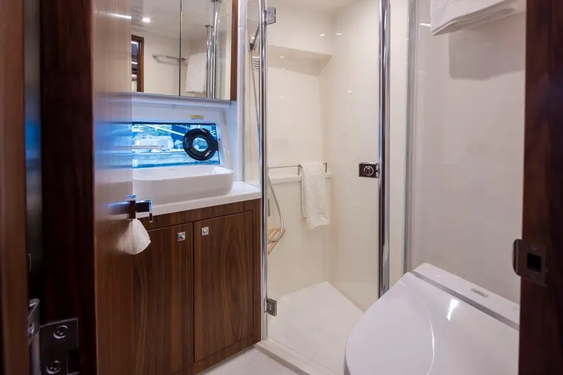 Slide: The Image of Luxurious bathroom in 2023 Riviera 505 SUV yacht with modern fixtures and wood accents. - 25