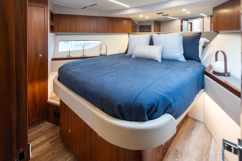 Slide: The Image of Luxurious bedroom interior of 2023 Riviera 505 SUV yacht with elegant wood finishes. - 27