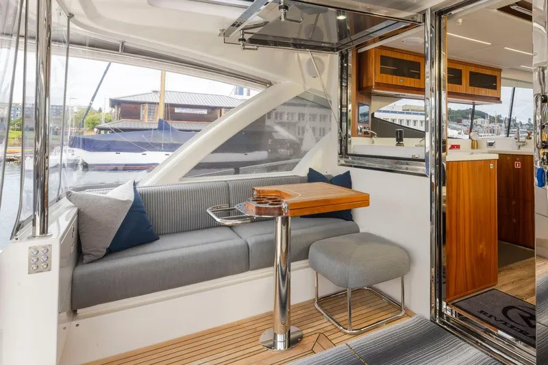 Slide: The Image of 2023 Riviera 505 SUV interior with elegant seating and wooden accents, docked at marina. - 33