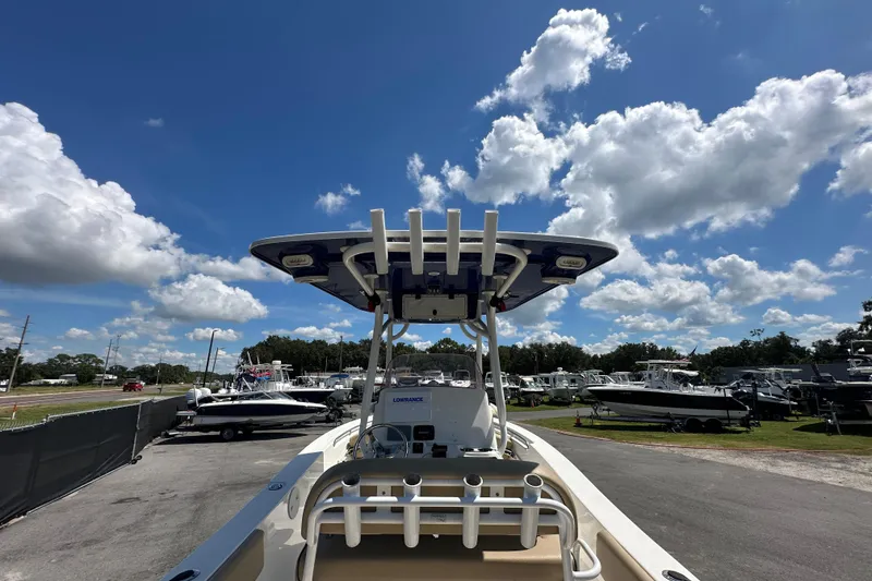 Slide: The Image of 2020 NauticStar 2302 Legacy boat under a bright blue sky with scattered clouds. - 14