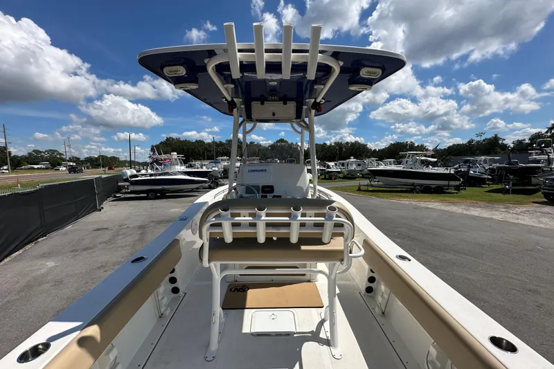 Slide: The Image of 2020 NauticStar 2302 Legacy boat with T-top, parked outdoors under a cloudy sky. - 15