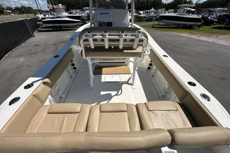 Slide: The Image of 2020 NauticStar 2302 Legacy boat interior with beige seating and fishing rod holders. - 16