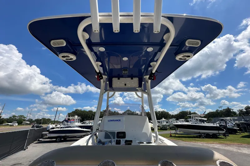 Slide: The Image of 2020 NauticStar 2302 Legacy boat with blue T-top under a bright sky. - 17