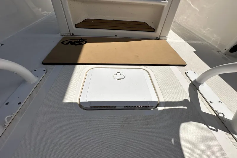 Slide: The Image of 2020 NauticStar 2302 Legacy boat deck with storage hatch and mat. - 20