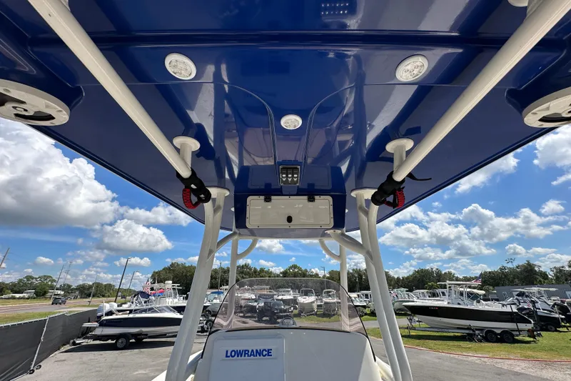Slide: The Image of 2020 NauticStar 2302 Legacy boat with blue T-top and Lowrance equipment, under a sunny sky. - 24