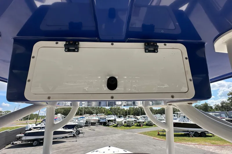 Slide: The Image of 2020 NauticStar 2302 Legacy boat console with storage compartment, marina background. - 27